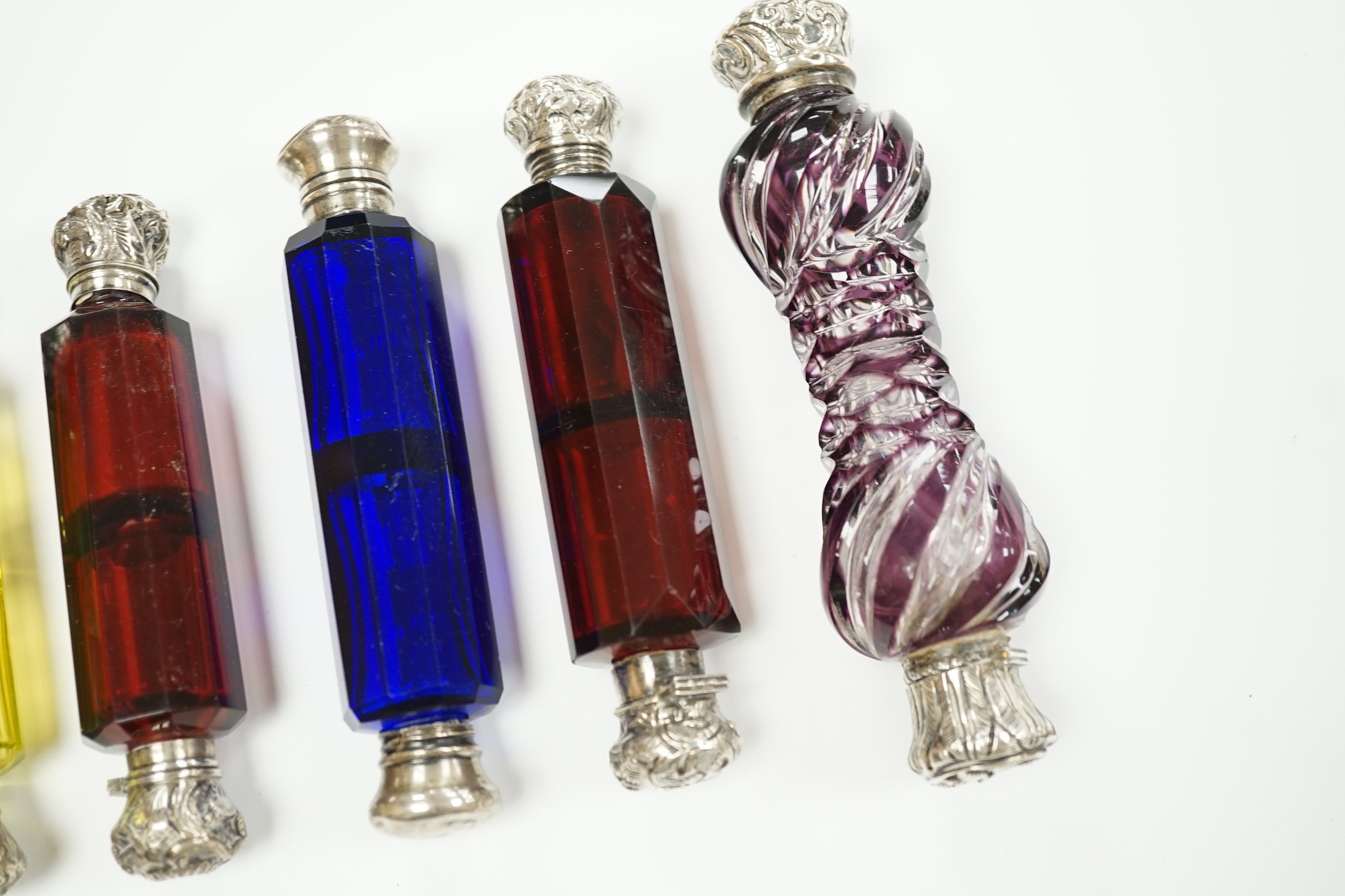 Six assorted late 19th/early 20th century white metal mounted coloured glass double ended scent bottles including pale green, 14.9cm and amethyst flash, 13.7cm (some a.f.)